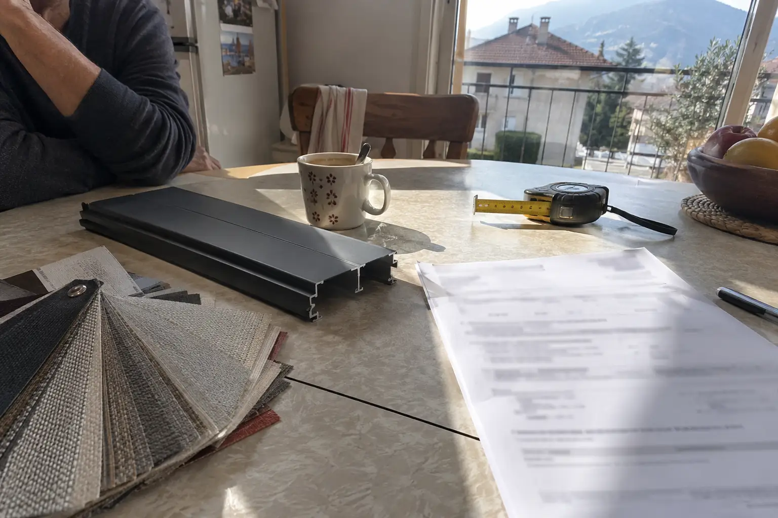 Table de cuisine avec un devis imprimé, un nuancier de toiles, un profil de lame et un mètre ruban
